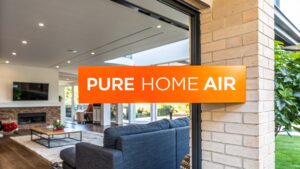 Modern living room with "PURE HOME AIR" sign, highlighting air purification in home environments, relevant to whole house air purification systems.