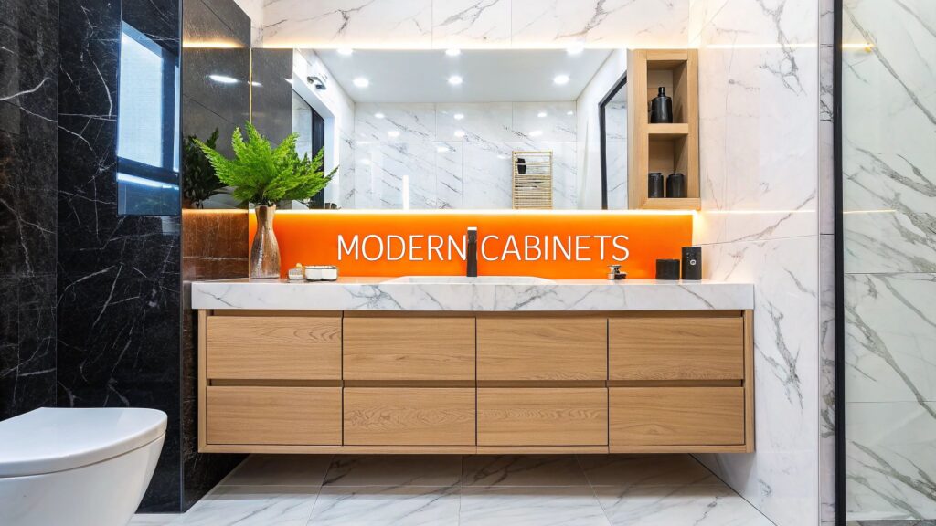 Modern bathroom cabinet design featuring sleek wooden cabinetry, marble countertop, illuminated signage reading "MODERN CABINETS," and stylish decor elements, emphasizing contemporary aesthetics for Orange County home remodels.